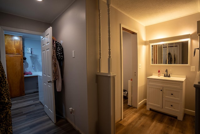 hall with dark hardwood / wood-style floors, sink, and a textured ceiling