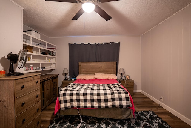 bedroom with ceiling fan, dark wood-type flooring, and a textured ceiling