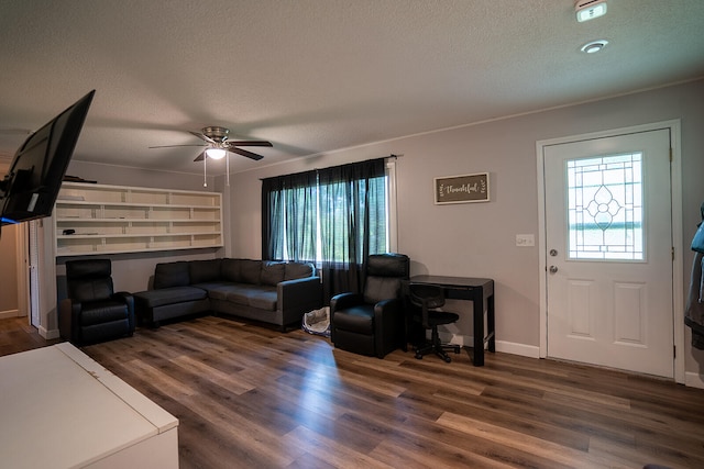 living room featuring ceiling fan, dark hardwood / wood-style flooring, and a textured ceiling