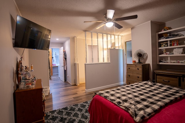 bedroom with ornamental molding, ceiling fan, light hardwood / wood-style floors, and a textured ceiling