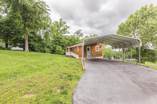 view of parking / parking lot featuring a yard and a carport