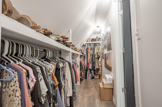 walk in closet with lofted ceiling and hardwood / wood-style floors