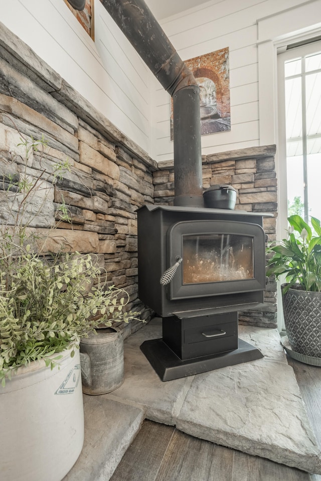 room details with wood-type flooring, wooden walls, and a wood stove