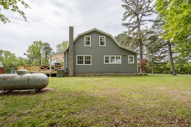 back of house featuring central air condition unit and a yard