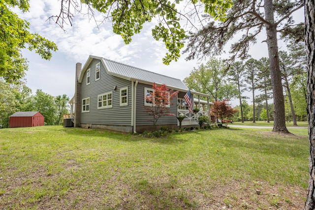 view of property exterior with central AC, a shed, and a lawn