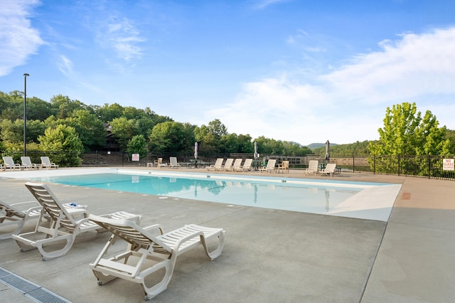 pool featuring fence and a patio