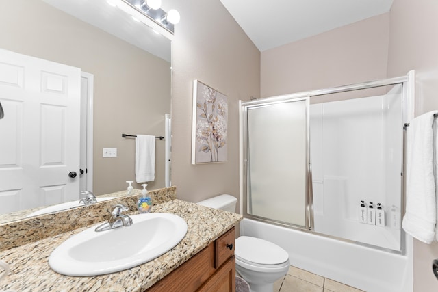 full bathroom featuring shower / bath combination with glass door, vanity, tile patterned flooring, and toilet