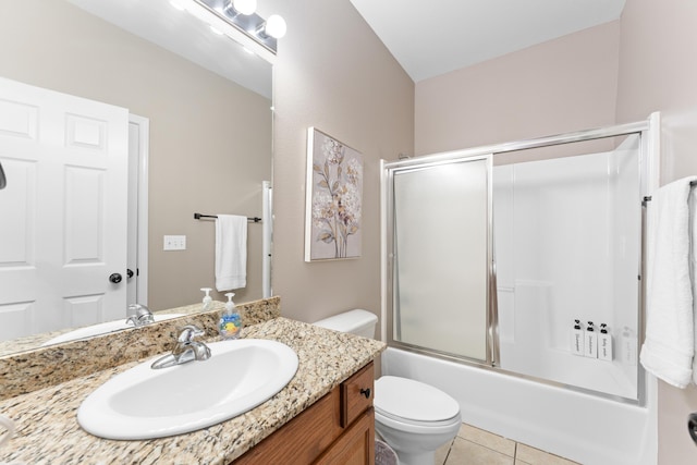 bathroom featuring combined bath / shower with glass door, vanity, tile patterned flooring, and toilet