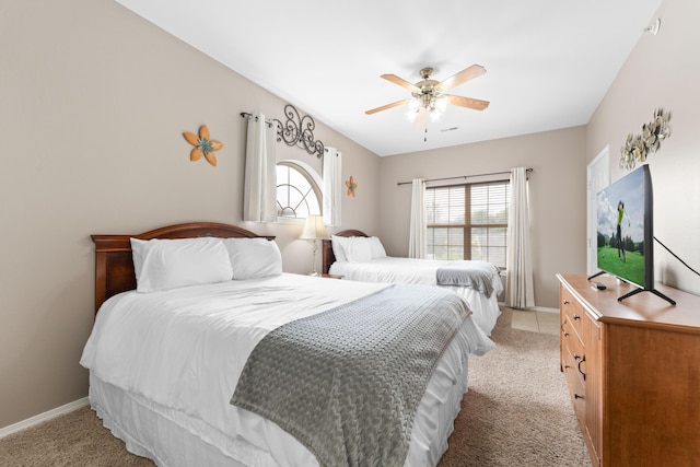 bedroom with a ceiling fan, baseboards, and light carpet