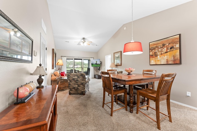 carpeted dining space featuring high vaulted ceiling and ceiling fan