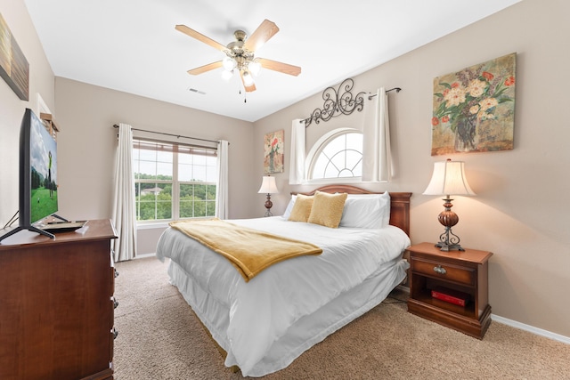 bedroom featuring ceiling fan, visible vents, baseboards, and light carpet