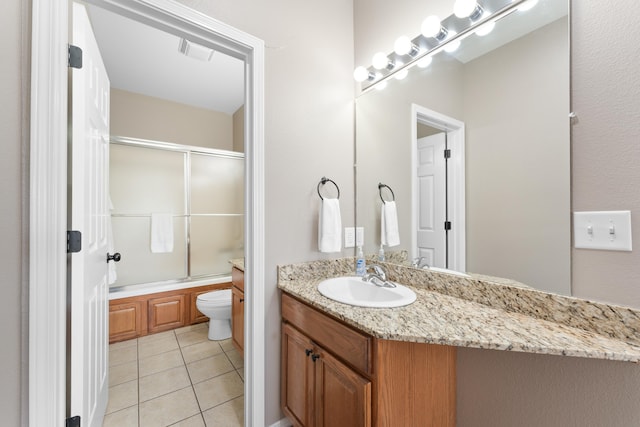 full bath with tile patterned floors, bath / shower combo with glass door, toilet, visible vents, and vanity