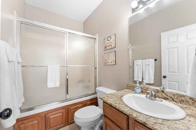 full bathroom with bath / shower combo with glass door, vanity, tile patterned flooring, and toilet