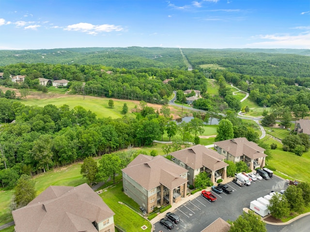 drone / aerial view with a residential view, golf course view, a forest view, and a water view