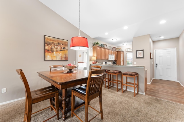 dining room with recessed lighting, light carpet, and baseboards