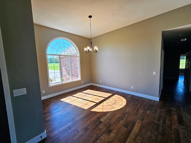 unfurnished dining area featuring an inviting chandelier and dark hardwood / wood-style flooring