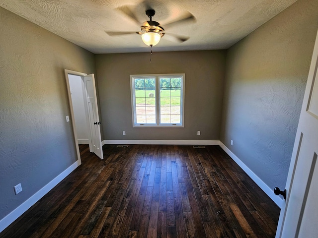 spare room with dark wood-type flooring, a textured ceiling, and ceiling fan