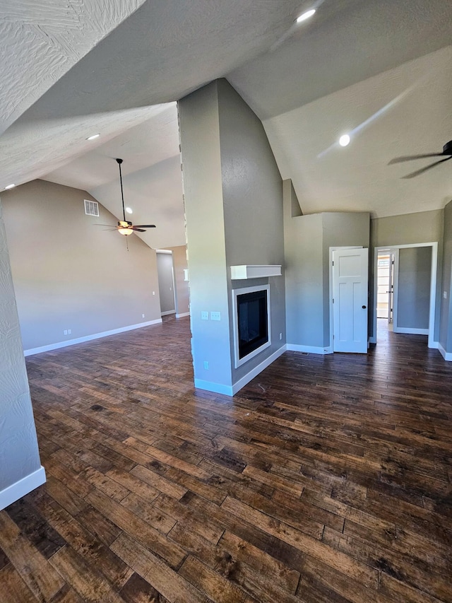 unfurnished living room featuring lofted ceiling, ceiling fan, and dark wood-type flooring