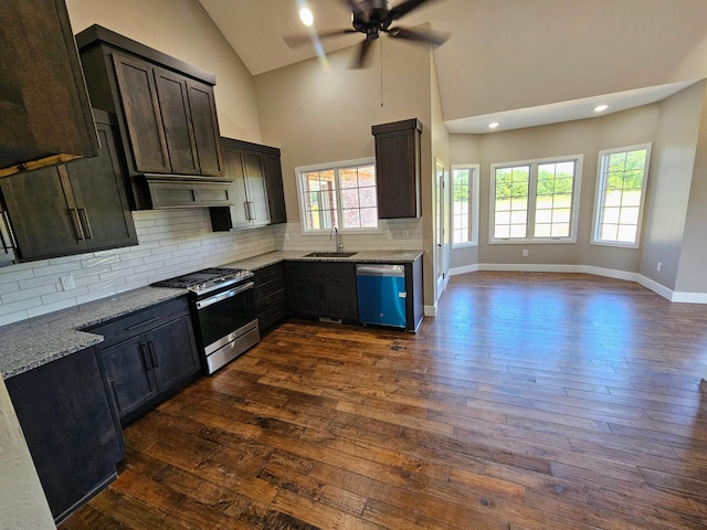 kitchen with light stone counters, stainless steel appliances, sink, and dark hardwood / wood-style flooring