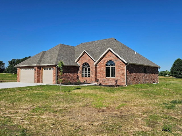 view of front of home with a front yard and a garage