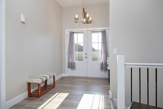 entryway with french doors, wood finished floors, baseboards, and an inviting chandelier