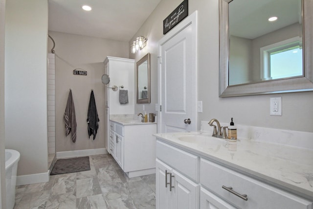bathroom featuring two vanities, marble finish floor, baseboards, and a sink
