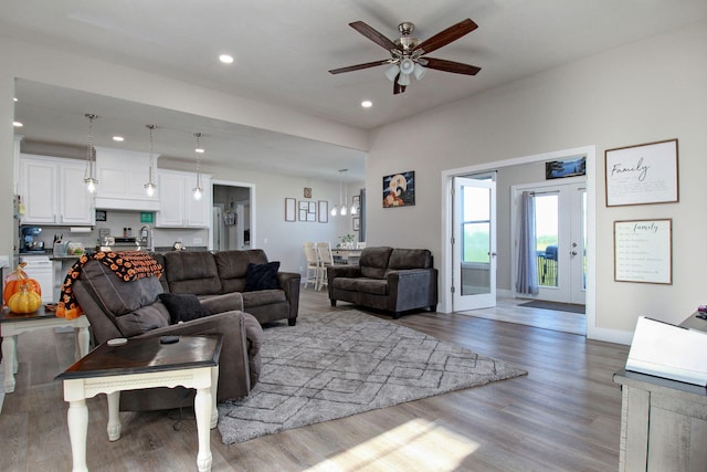 living room with ceiling fan, french doors, and light hardwood / wood-style floors