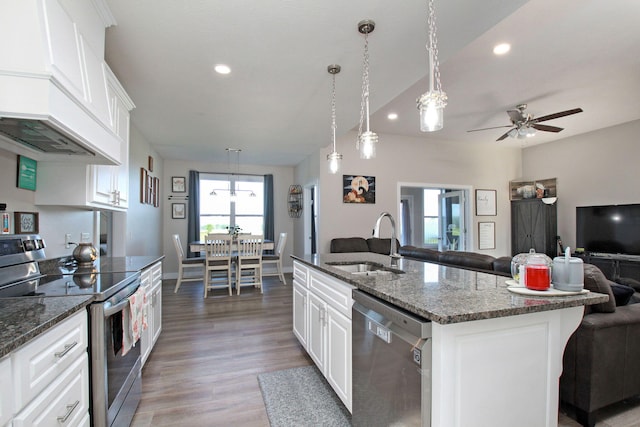 kitchen featuring stainless steel appliances, light wood-style flooring, a sink, open floor plan, and a ceiling fan