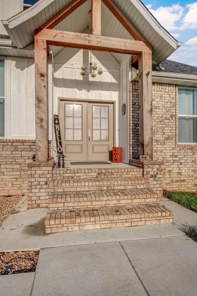 property entrance featuring brick siding and french doors