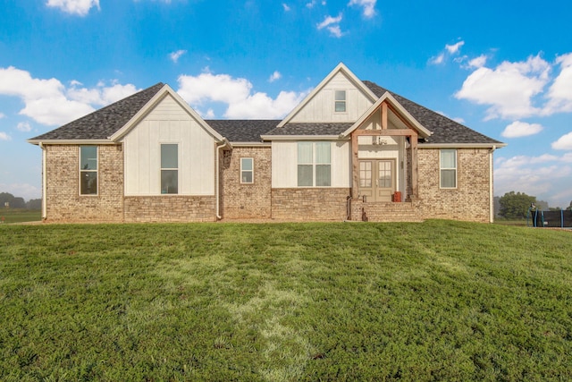 view of front of house featuring a shingled roof, french doors, and a front yard