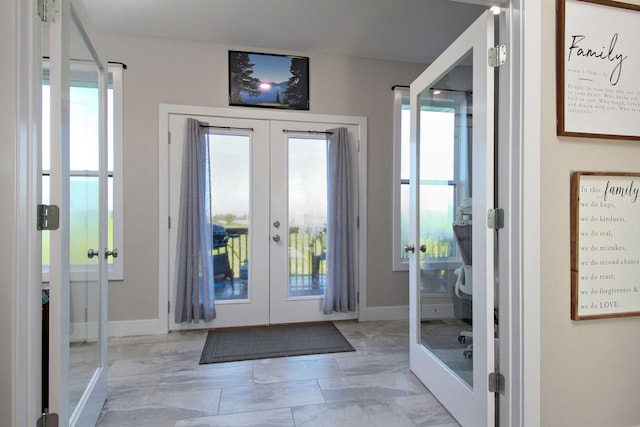 doorway featuring marble finish floor, baseboards, and french doors