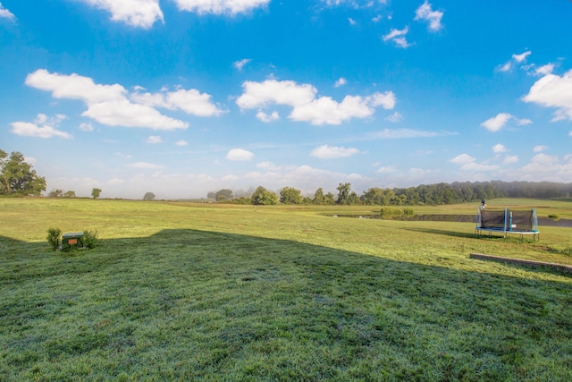 view of yard featuring a trampoline and a rural view