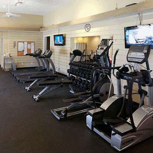 workout area featuring wooden walls and a textured ceiling