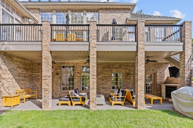 back of property with ceiling fan, a patio, outdoor lounge area, a yard, and a balcony