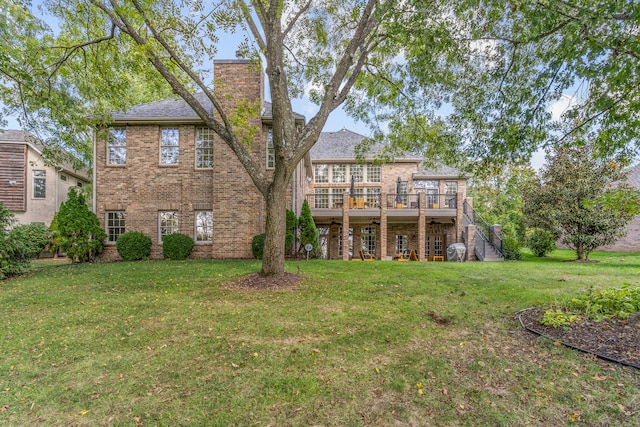 rear view of house featuring a yard and a deck