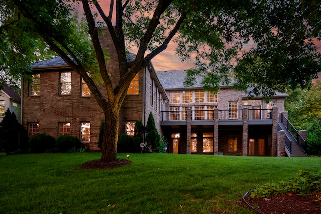 back house at dusk with a lawn