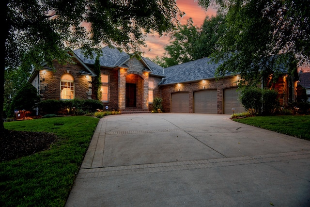 view of front of house with a garage and a lawn