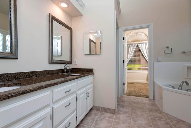 bathroom featuring a washtub, tile patterned floors, and vanity