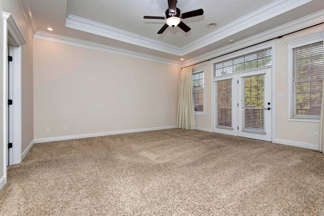 carpeted spare room featuring ornamental molding, ceiling fan, and a tray ceiling