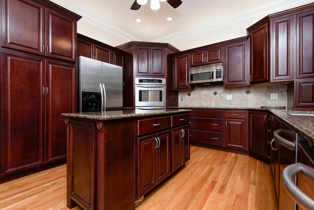 kitchen with tasteful backsplash, light hardwood / wood-style flooring, dark stone countertops, stainless steel appliances, and ornamental molding