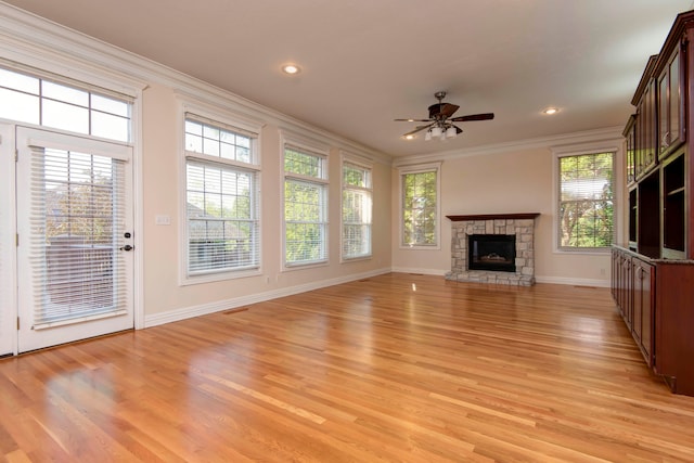 unfurnished living room featuring ceiling fan, ornamental molding, a fireplace, and light hardwood / wood-style floors