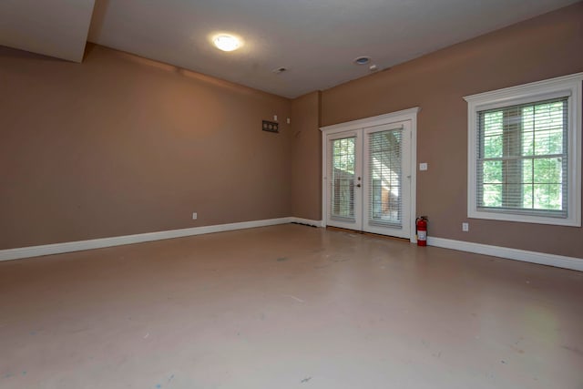 unfurnished room featuring a wealth of natural light, french doors, and concrete flooring