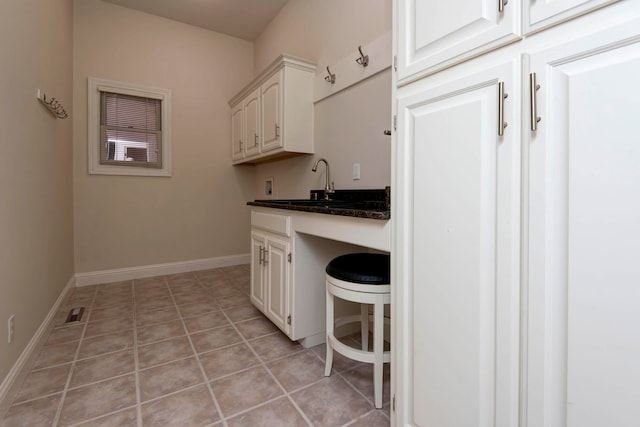 kitchen featuring light tile patterned floors and white cabinets