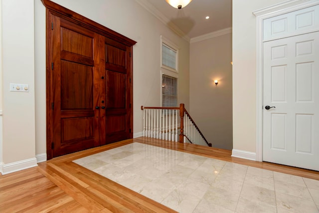 entryway with ornamental molding and light hardwood / wood-style floors