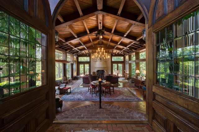 sunroom with lofted ceiling with beams, a chandelier, and wooden ceiling