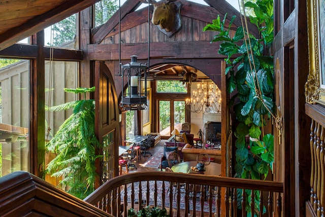 sunroom with a fireplace, vaulted ceiling, and a chandelier