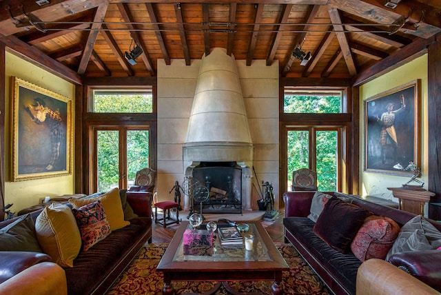 living room featuring vaulted ceiling with beams, wood ceiling, and a fireplace