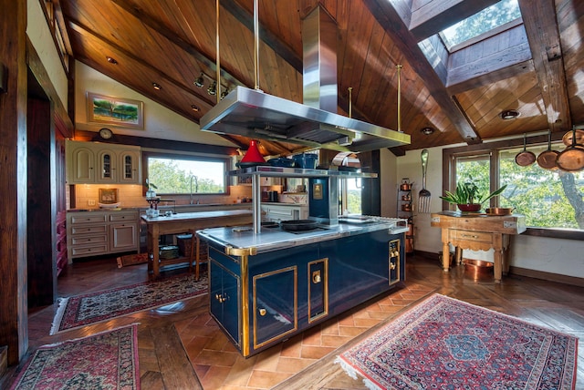 kitchen with a skylight, a kitchen island with sink, beamed ceiling, dark parquet flooring, and island range hood