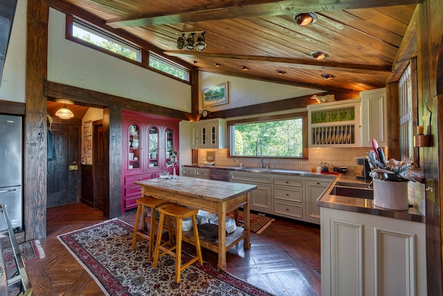 kitchen with dark parquet floors, wood ceiling, high vaulted ceiling, dishwasher, and white cabinets