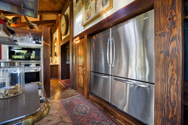 kitchen featuring beamed ceiling, stainless steel appliances, wood ceiling, and dark parquet flooring